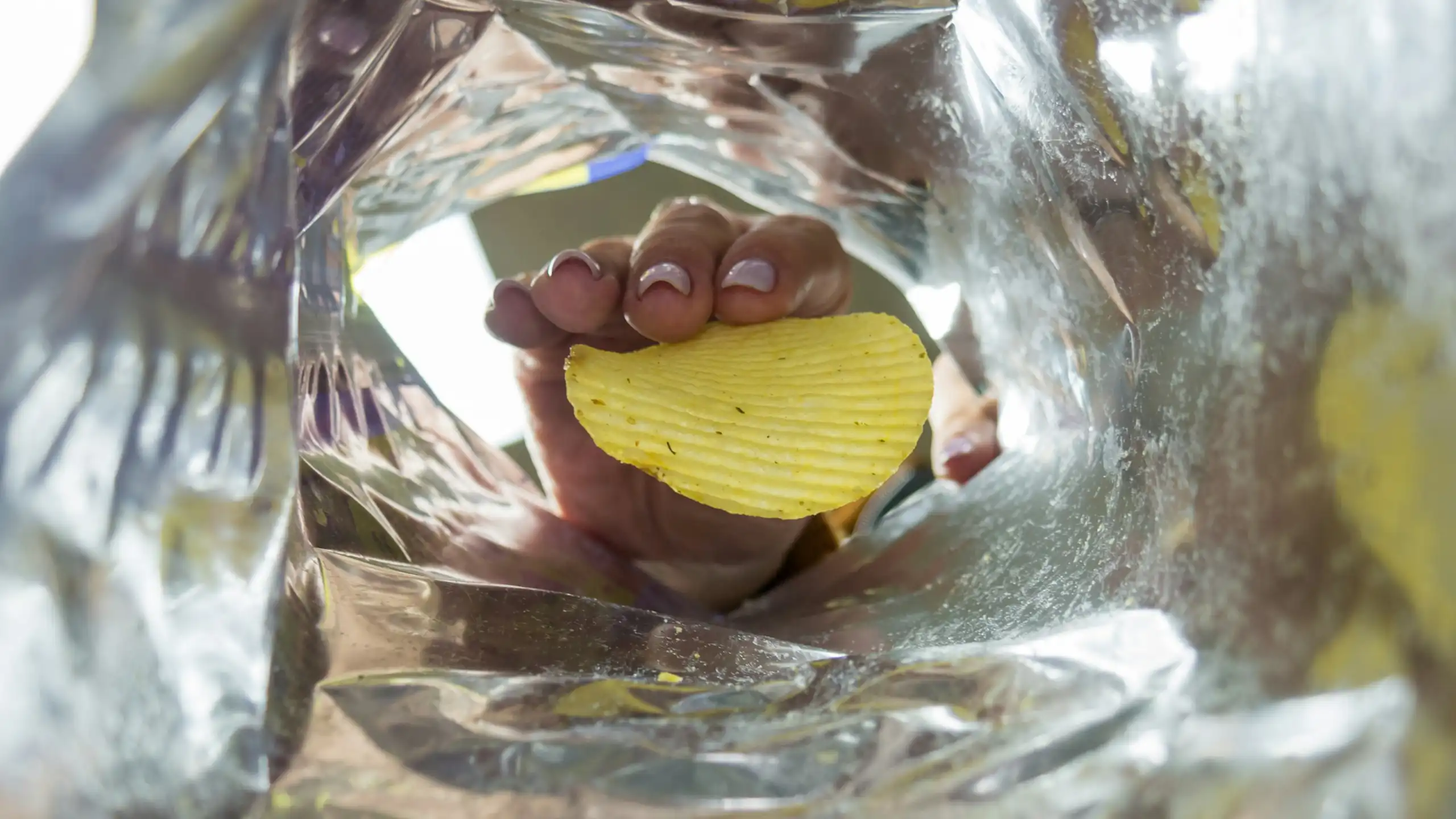 Quelqu'un attrape la dernière chips d'un paquet.