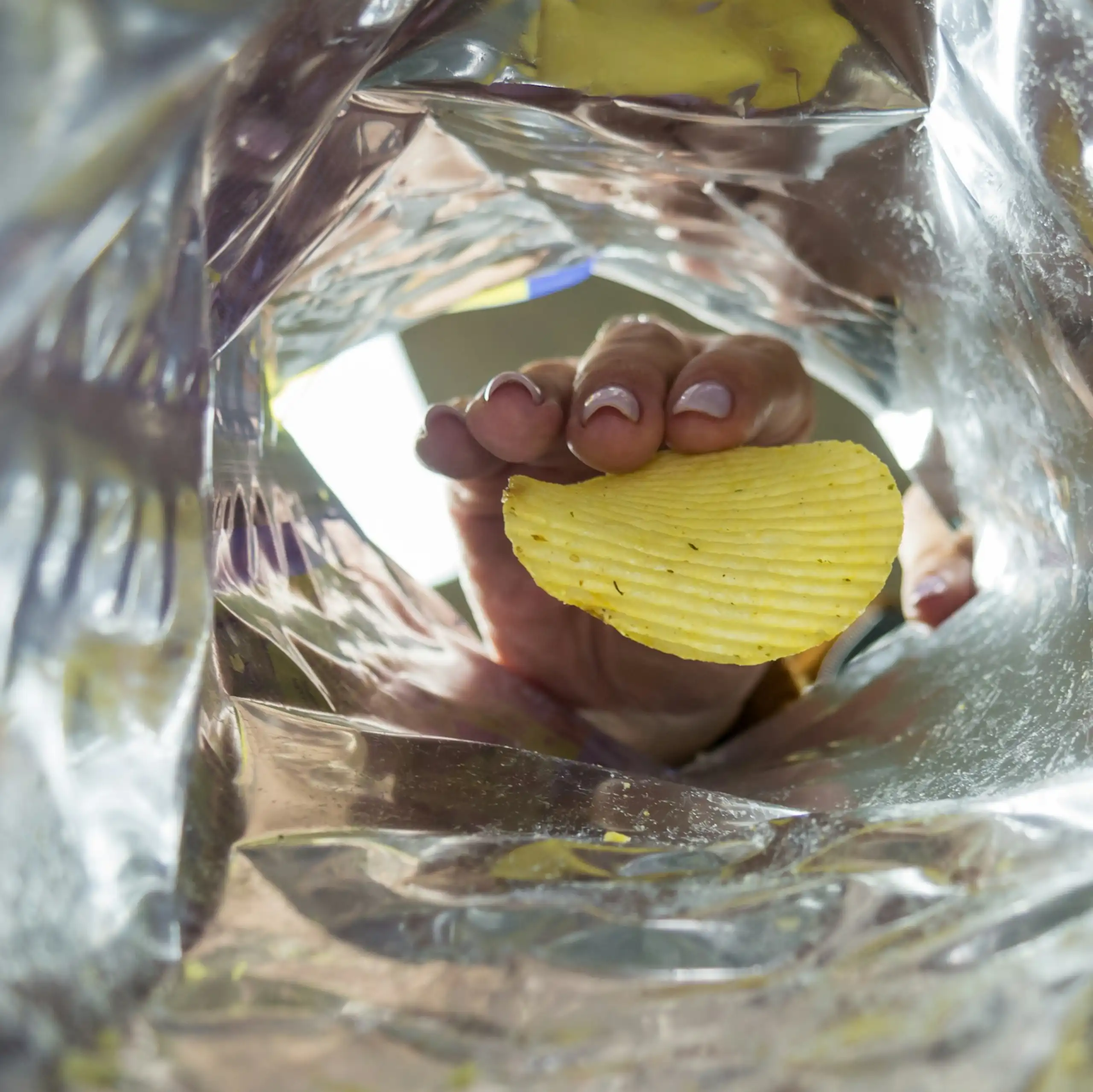 Quelqu'un attrape la dernière chips d'un paquet.