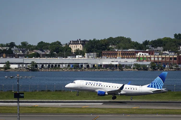 A small United jet lands at an airport.