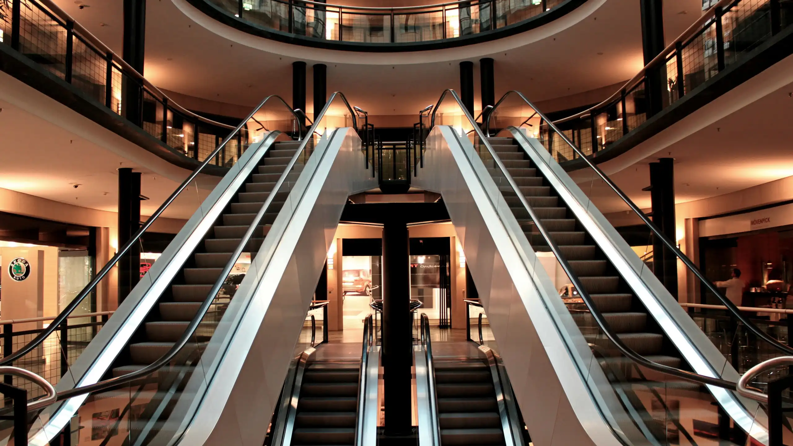 Escadas rolantes dentro de um shopping center vazio.
