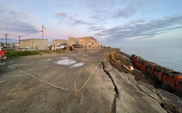 A coastal view with part of the low coastal bluff falling into the shore below.