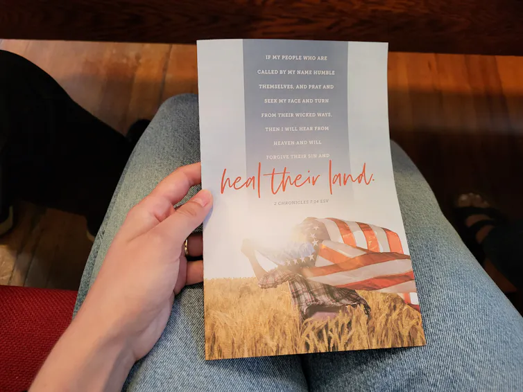 A flyer with a Bible verse on it shows an image of an American flag waving over a field, and the words 'heal their land.'