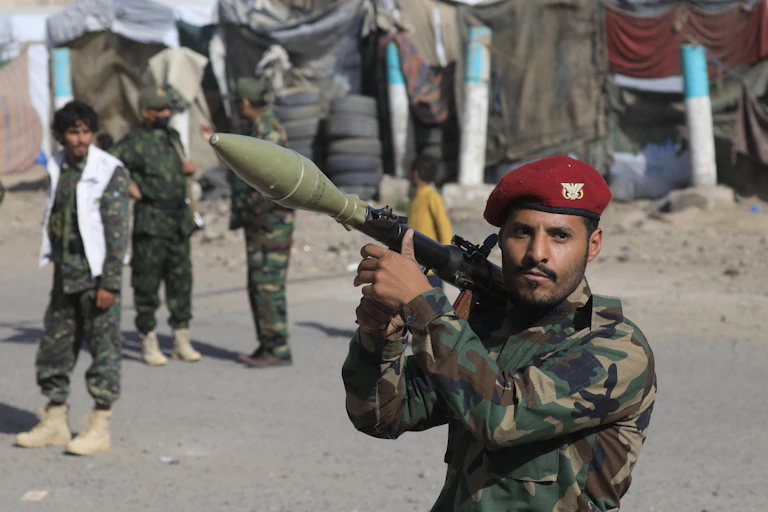 A Houthi fighter carries a rocket-propelled grenade launcher.