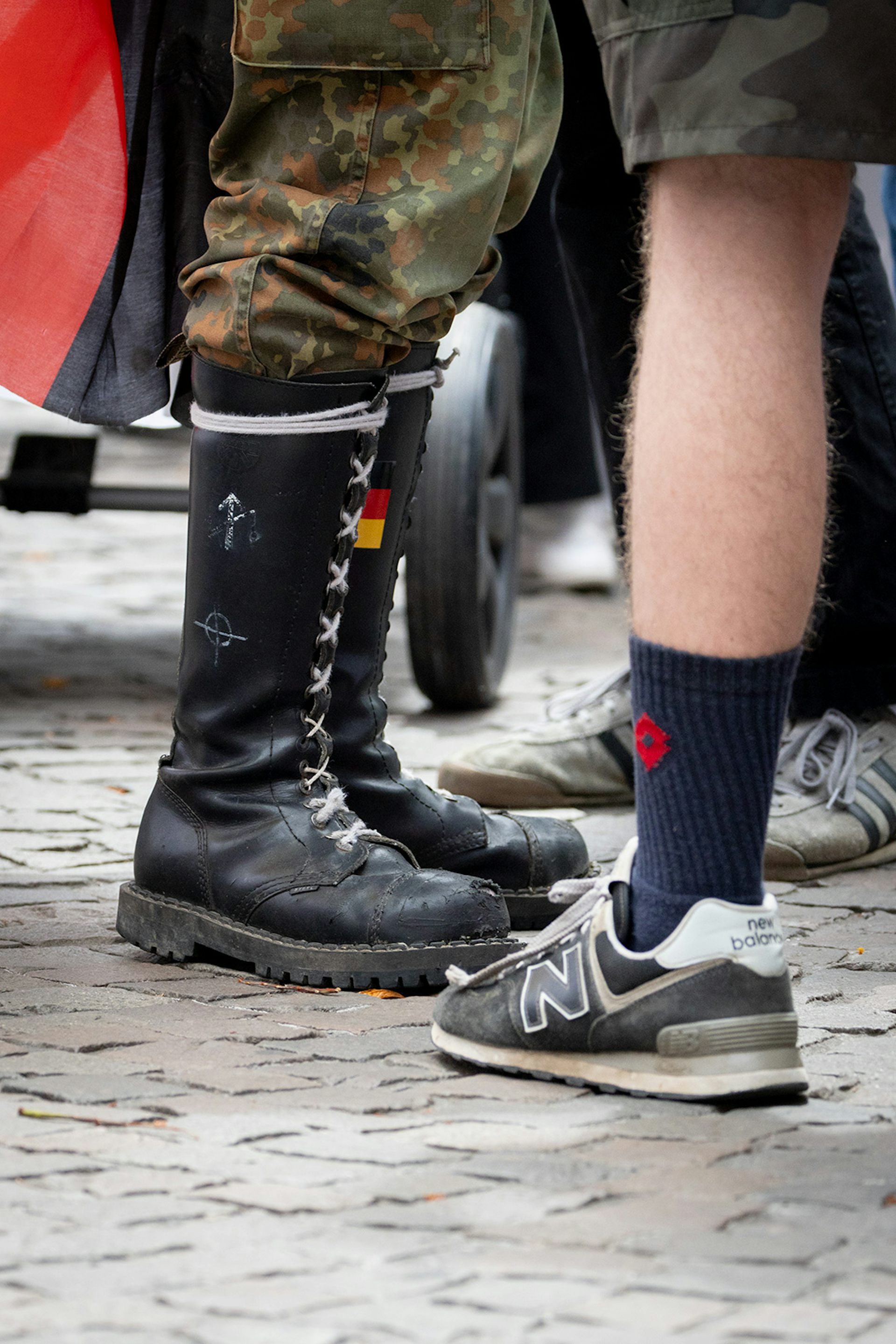 New Balance trainers next to rune-branded jackboots at a Neo-Nazi march