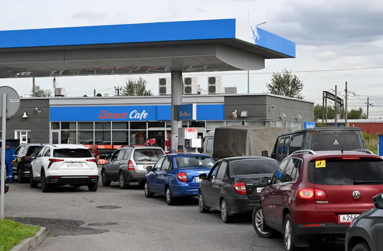 A long line of cars is seen outside a gas station.