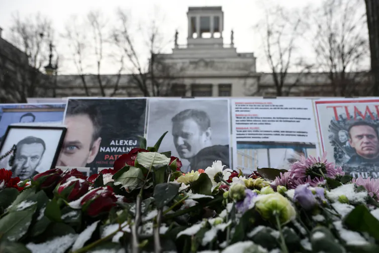 Flower lay in front of photos of a man.