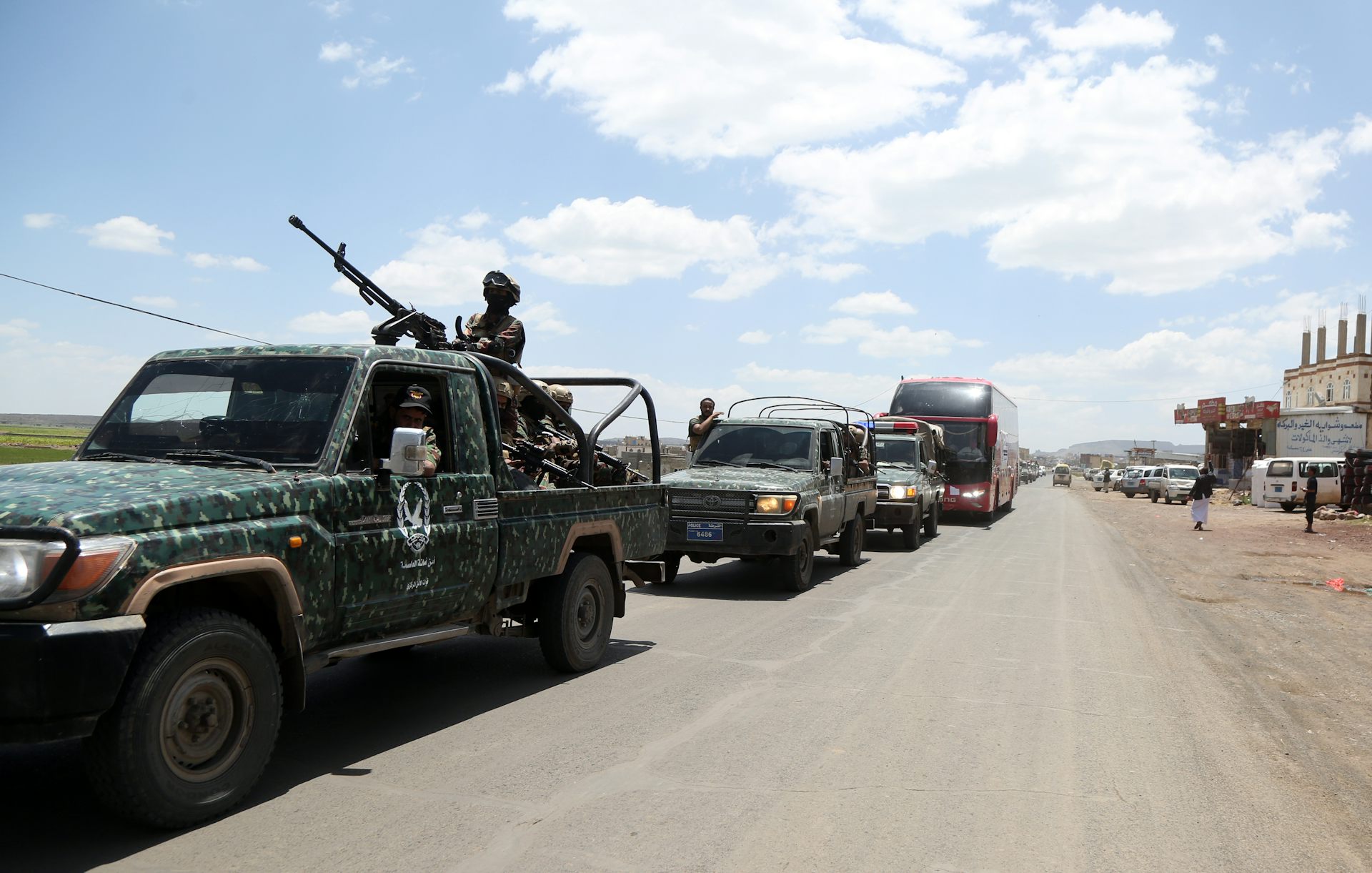 A gun-mounted truck leads a convoy of vehicles.