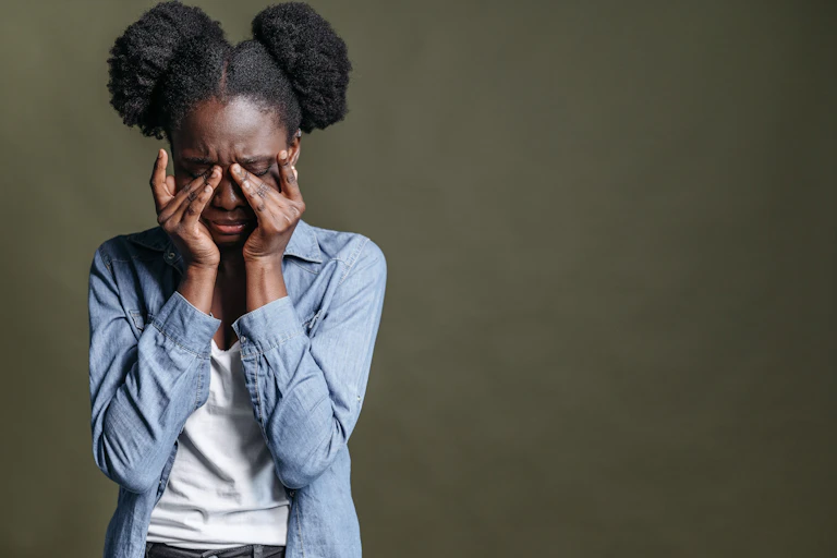 A woman clutches her sinuses, looking pained