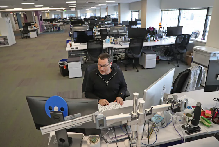 A man works at an otherwise empty and large office.