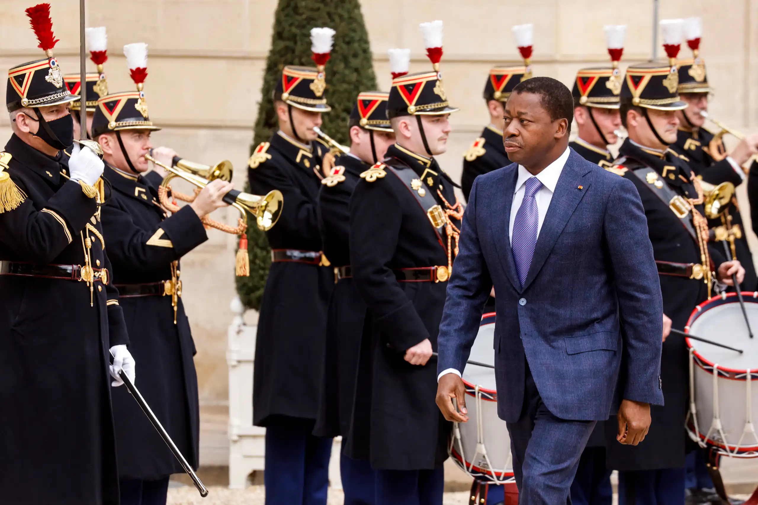 Faure Gnassingbé Eyadéma marchant vers l'entrée de l'Élysée, la Garde républicaine en arrière-plan.