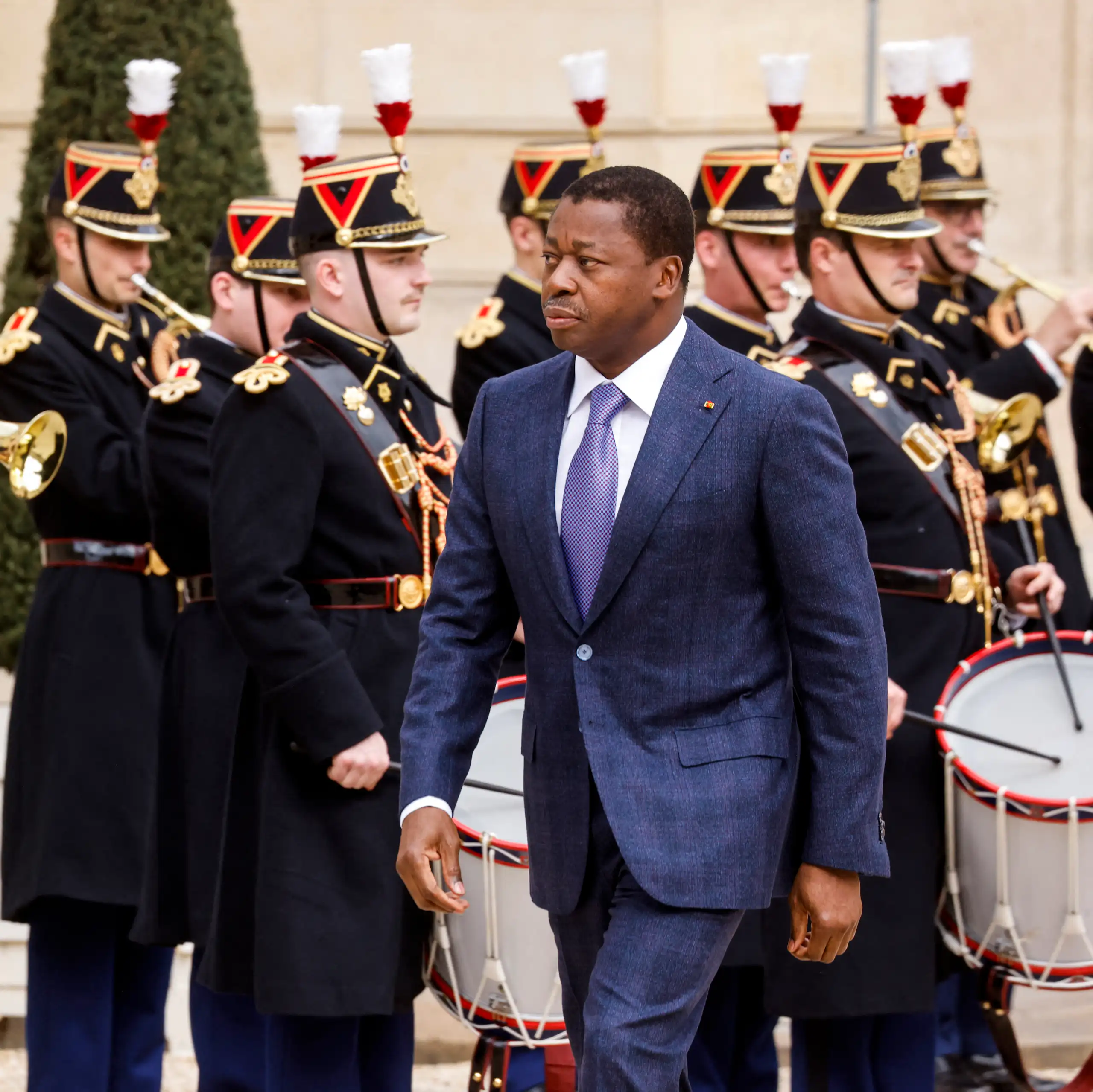 Faure Gnassingbé Eyadéma marchant vers l'entrée de l'Élysée, la Garde républicaine en arrière-plan.