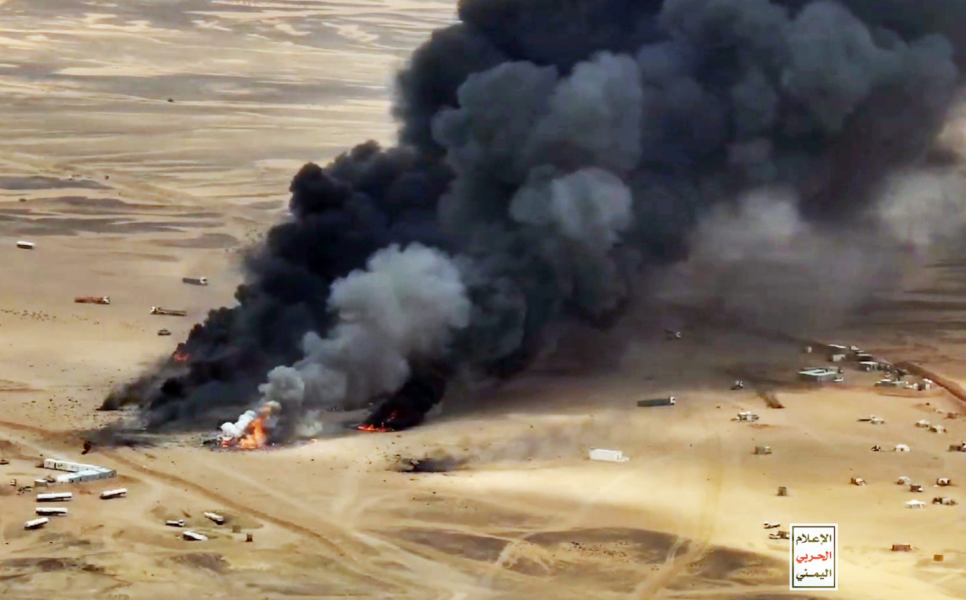 A black plume of sm okes rises from the desert.