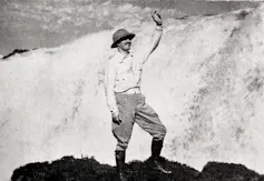 Foto em preto e branco mostra um homem no alto de uma montanha