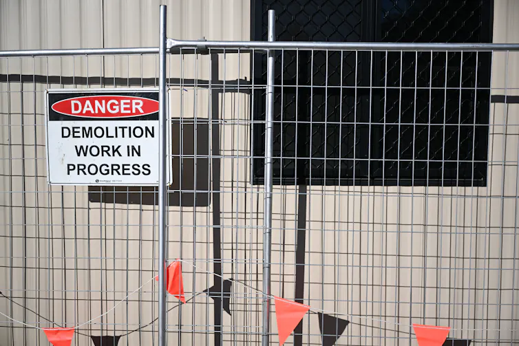 A demolition sign is seen at a redevelopment site