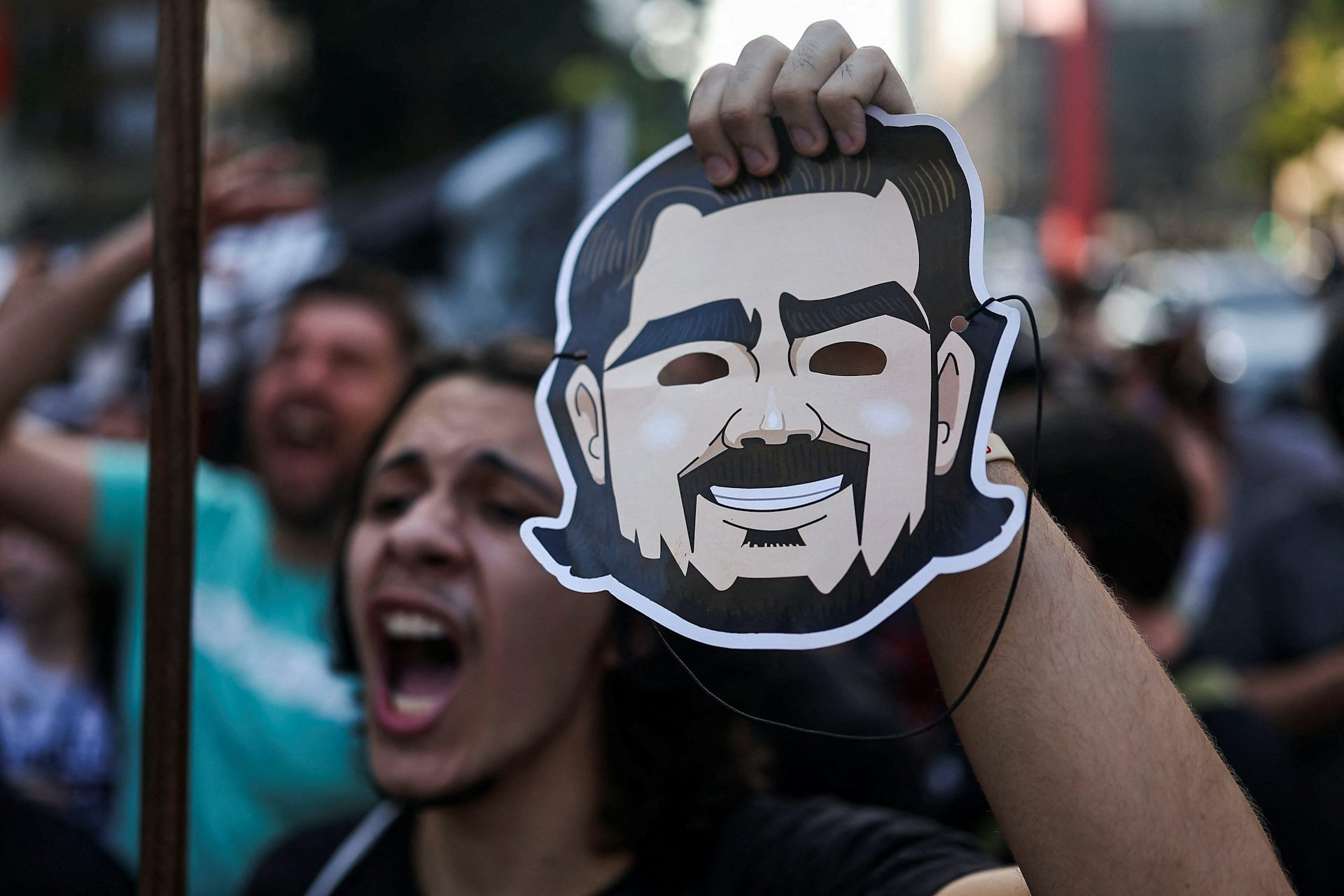 Un manifestante sostiene una máscara que representa al exbanquero brasileño Daniel Vorcaro
