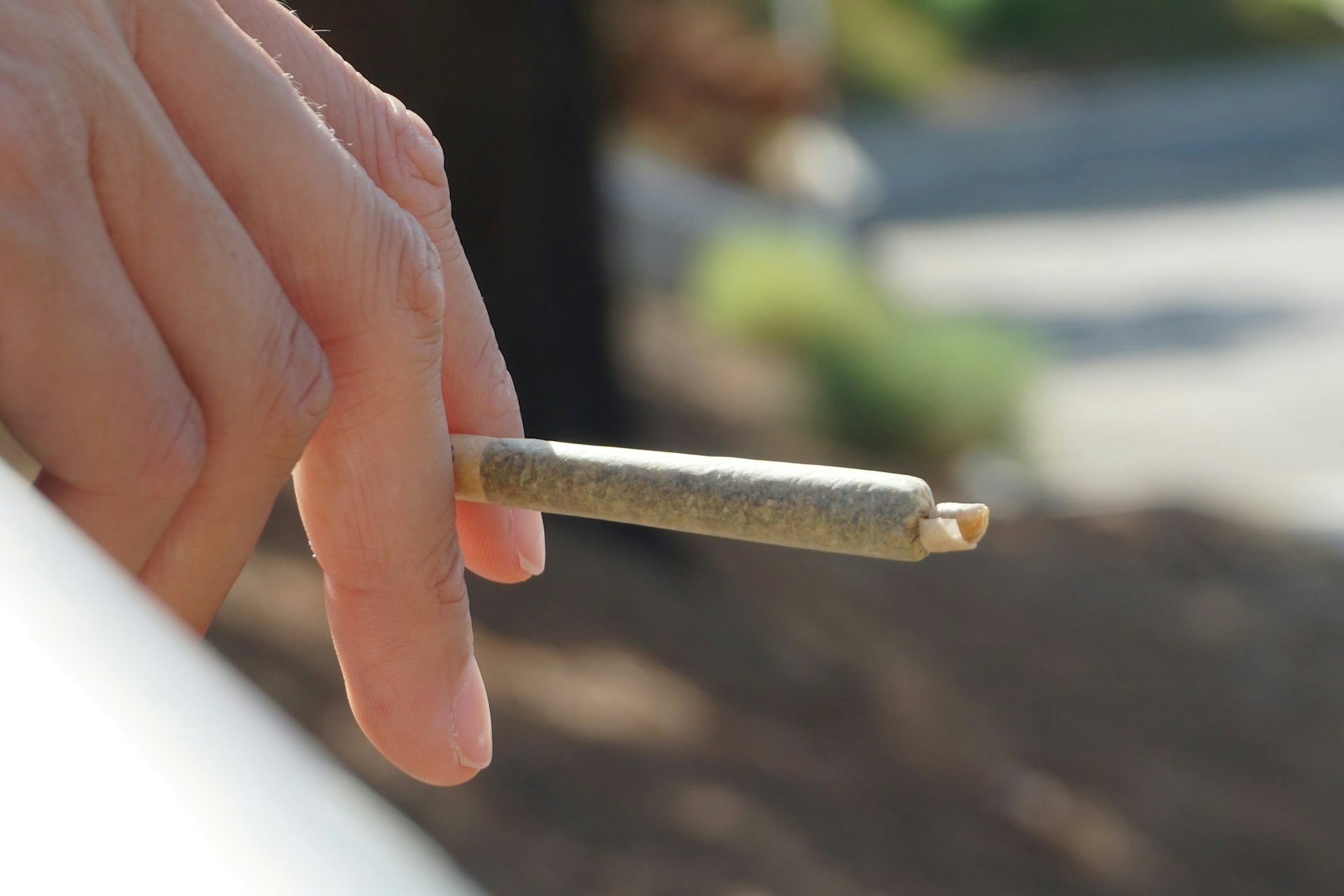 Main d’une personne tenant un joint