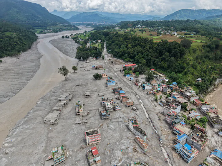 Mud covers a river-side village. The flood spread far from the river's banks, fully engulfing some homes.