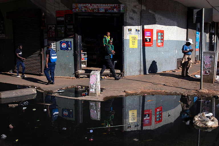 Puddle of water with floating pollution on a city street