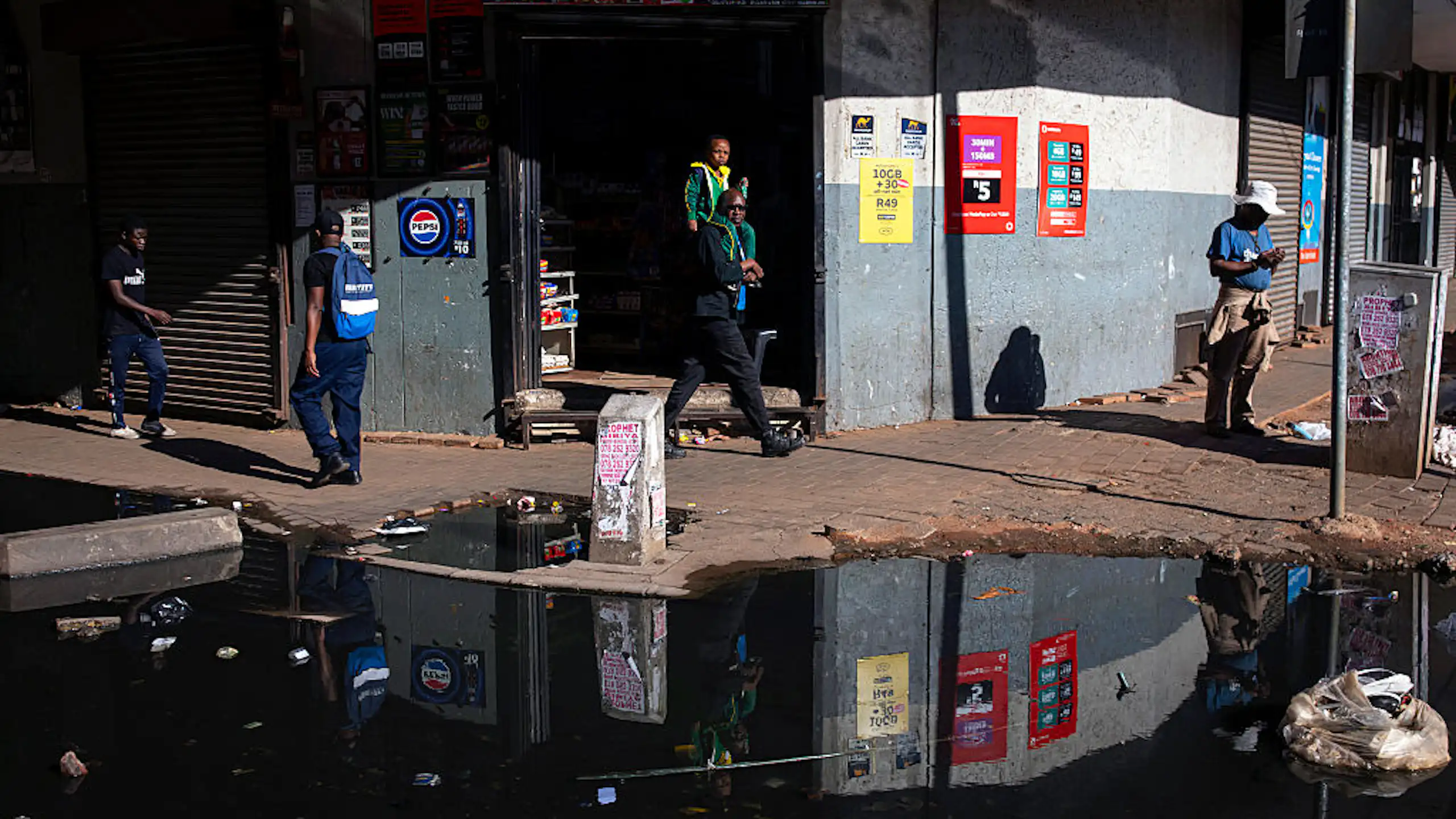 Puddle of water with floating pollution on a city street