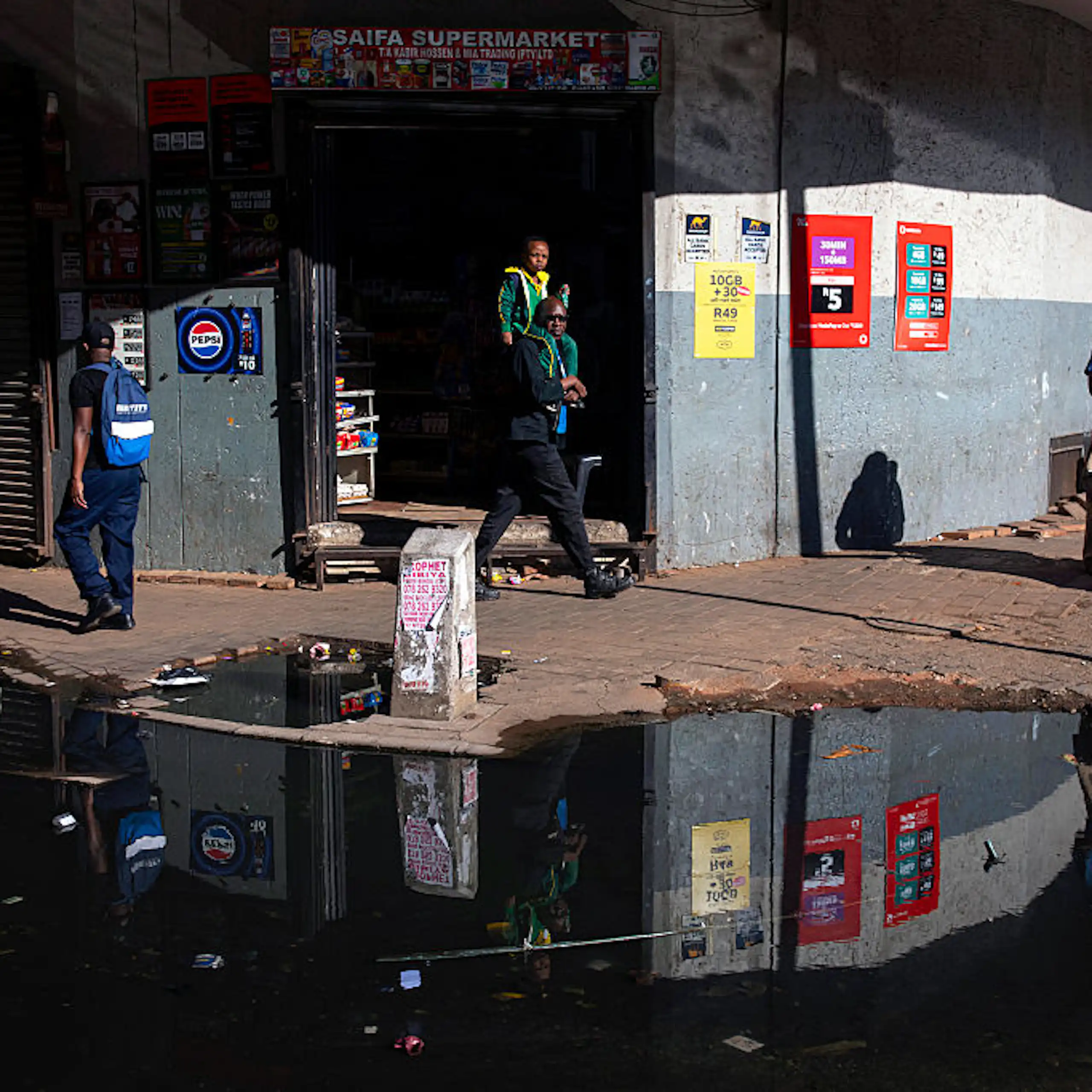 Puddle of water with floating pollution on a city street