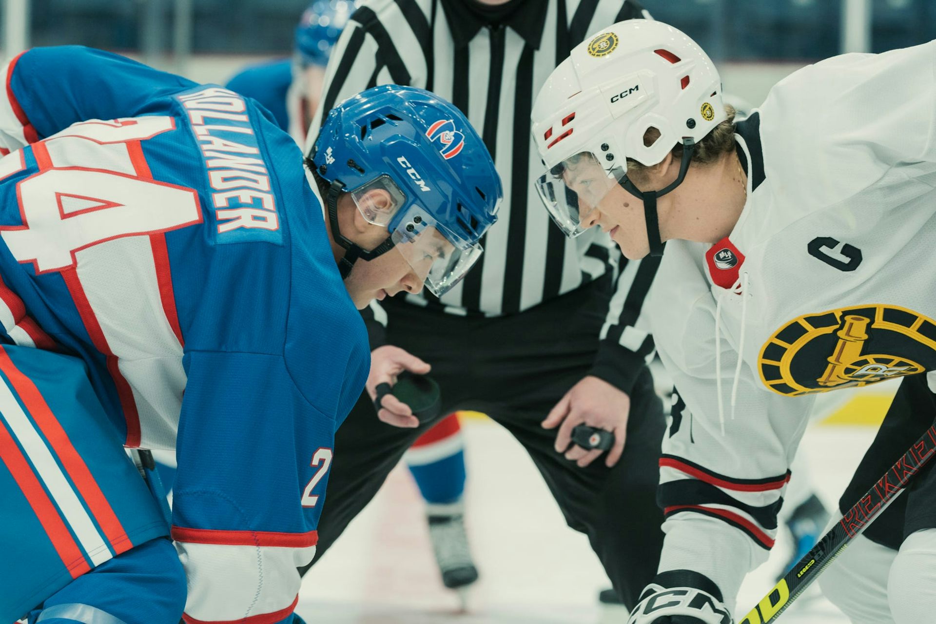 A still from a TV show showing two hockey players during a face-off