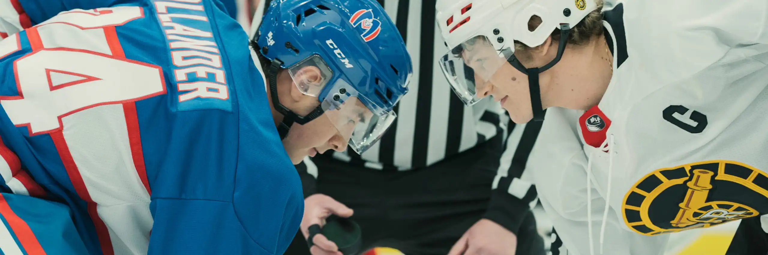 A still from a TV show showing two hockey players during a face-off