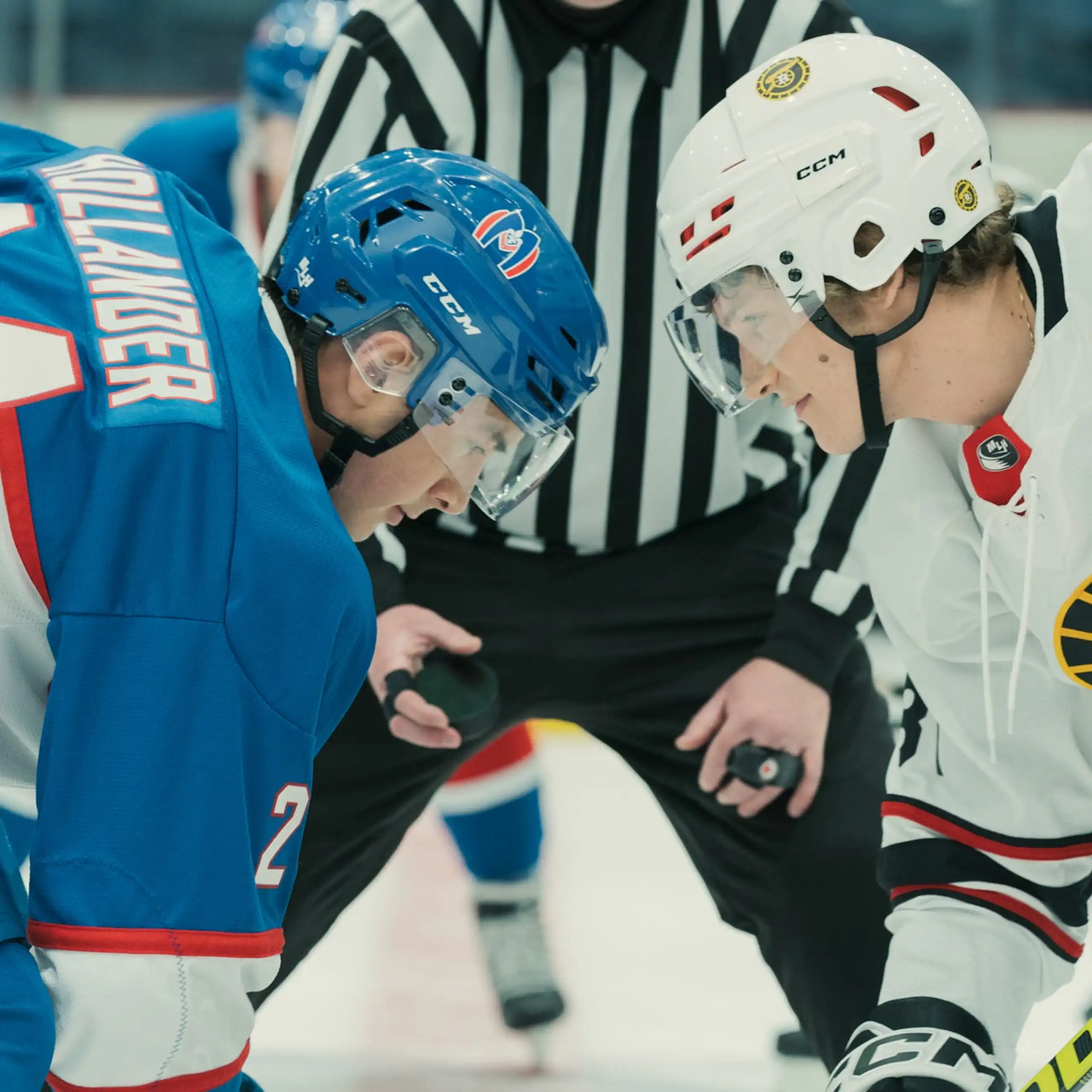 A still from a TV show showing two hockey players during a face-off