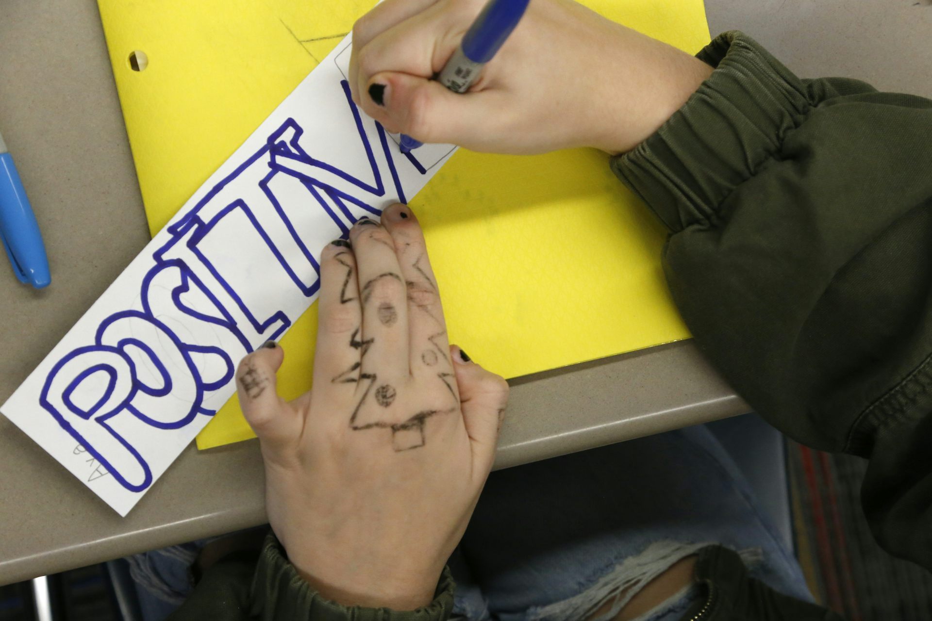 A student writing at desk in school