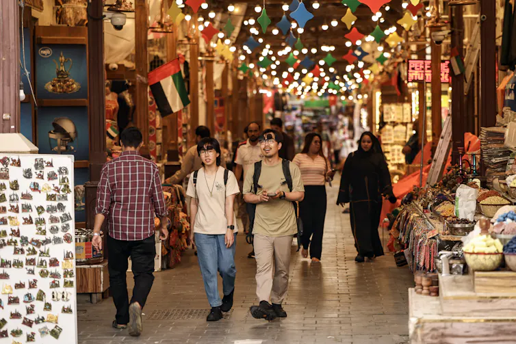 Tourists walk in a market in Dubai