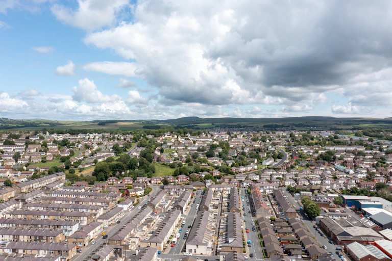Aerial photo of a town and distant hills.
