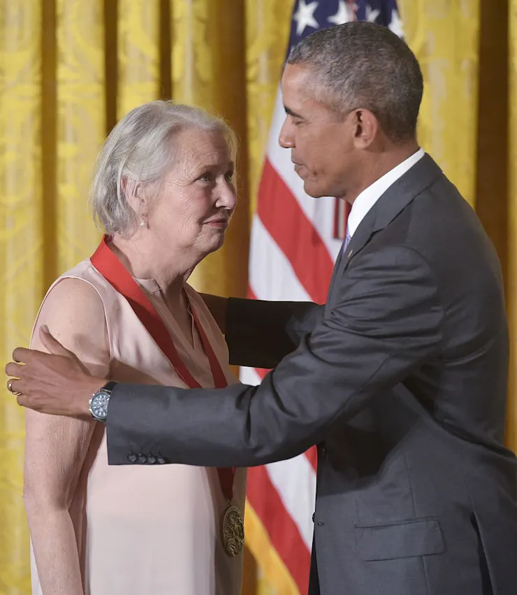 President Barack Obama with his hands on Annie Dillard's shoulders after placing a medal around her neck