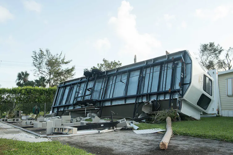 A mobile home rolled on its side with the bottom showing
