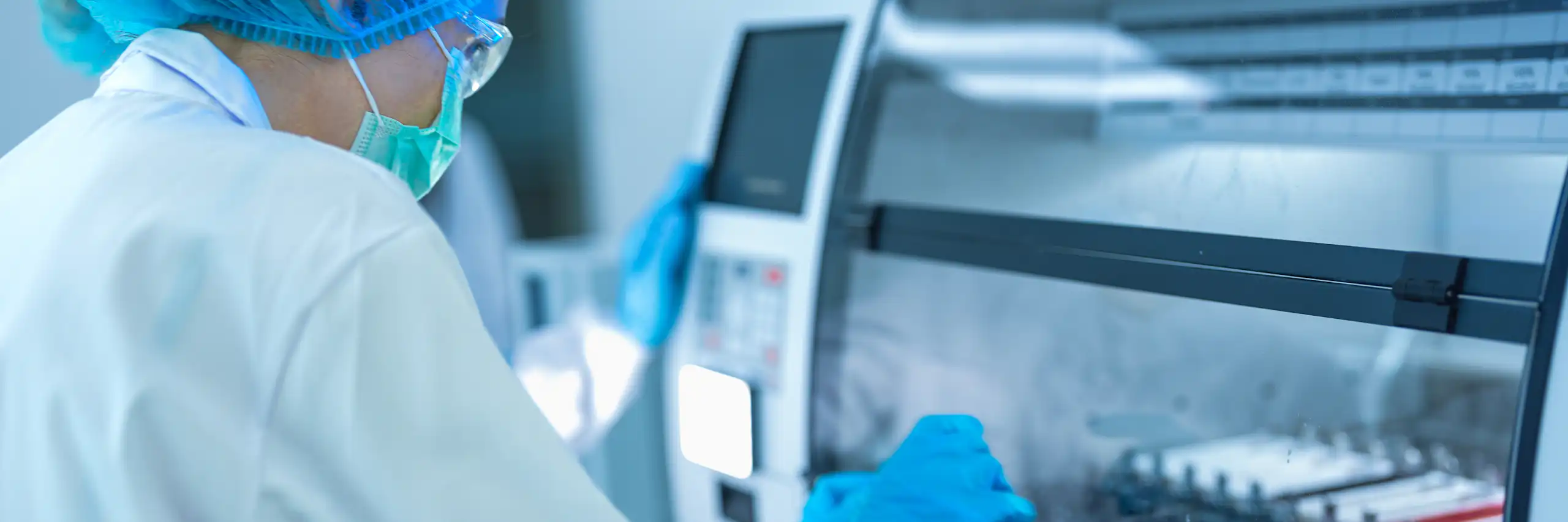 une laborantine en milieu stérile manipule des échantillons.