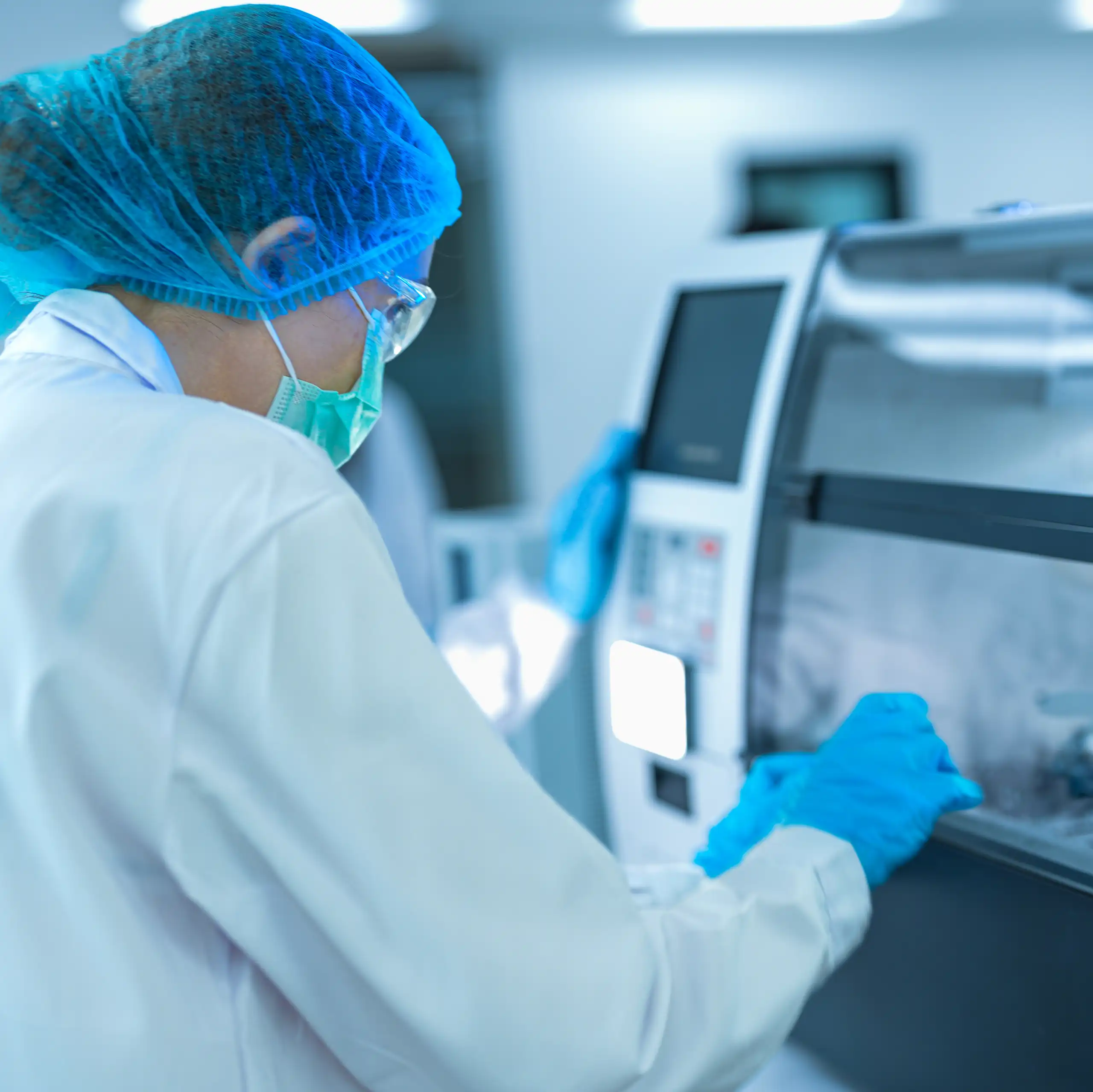une laborantine en milieu stérile manipule des échantillons.