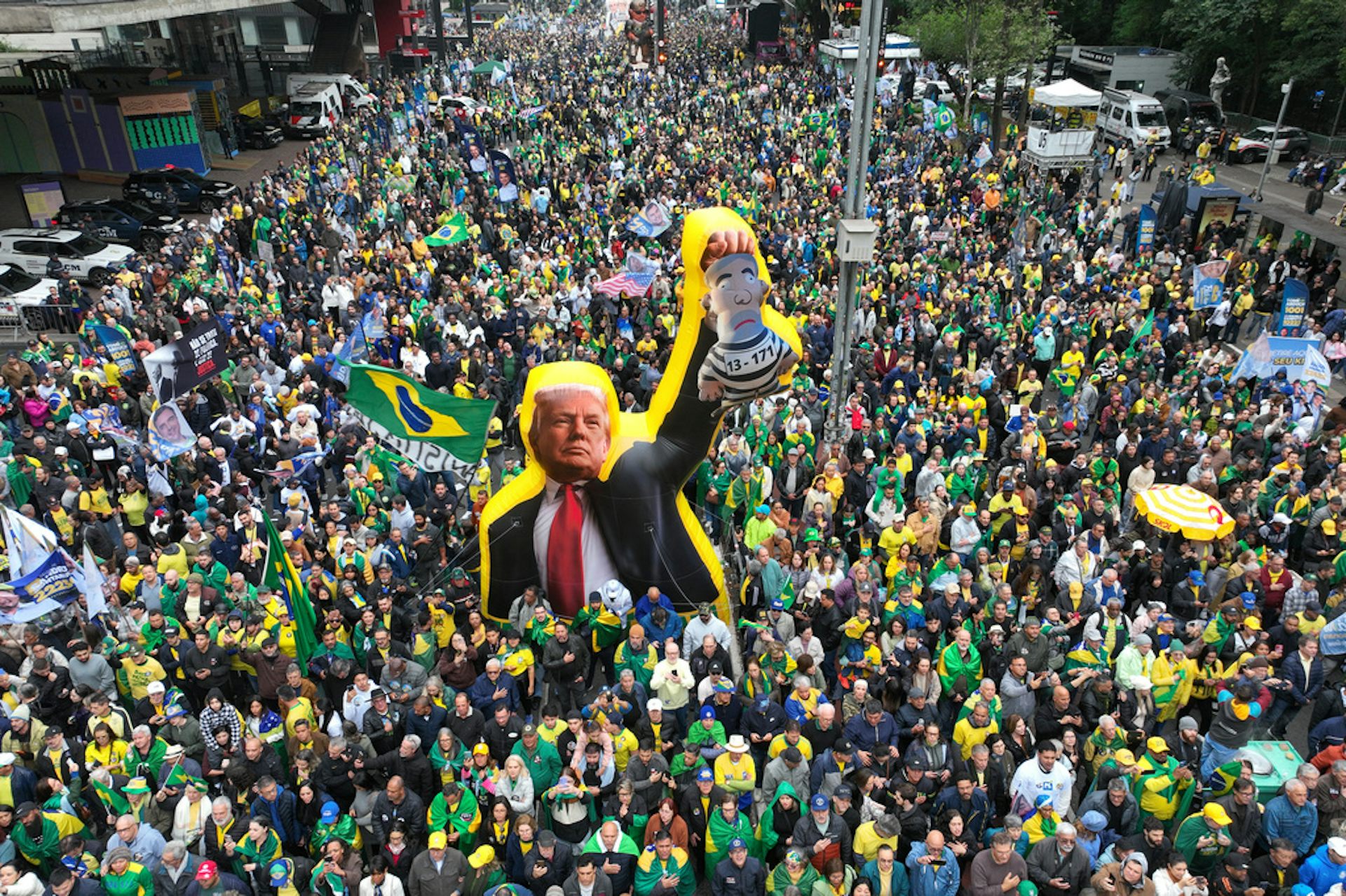 Throngs of demonstrators march with flags and a large effigy.