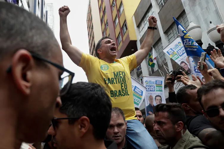 A man waves his hands in the air toward supporters.