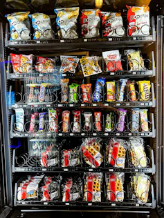 A vending machine filled with chips, chocolate bars and other packaged snacks