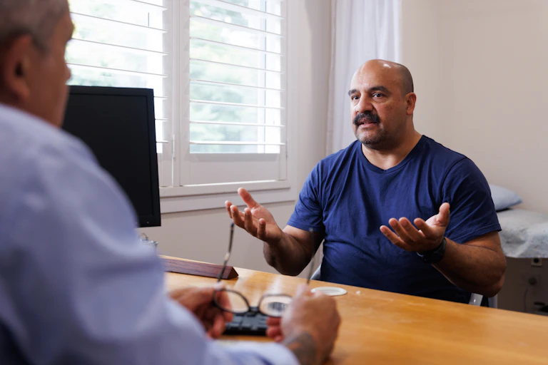 A middle-aged man talks to his GP about his PSA testing
