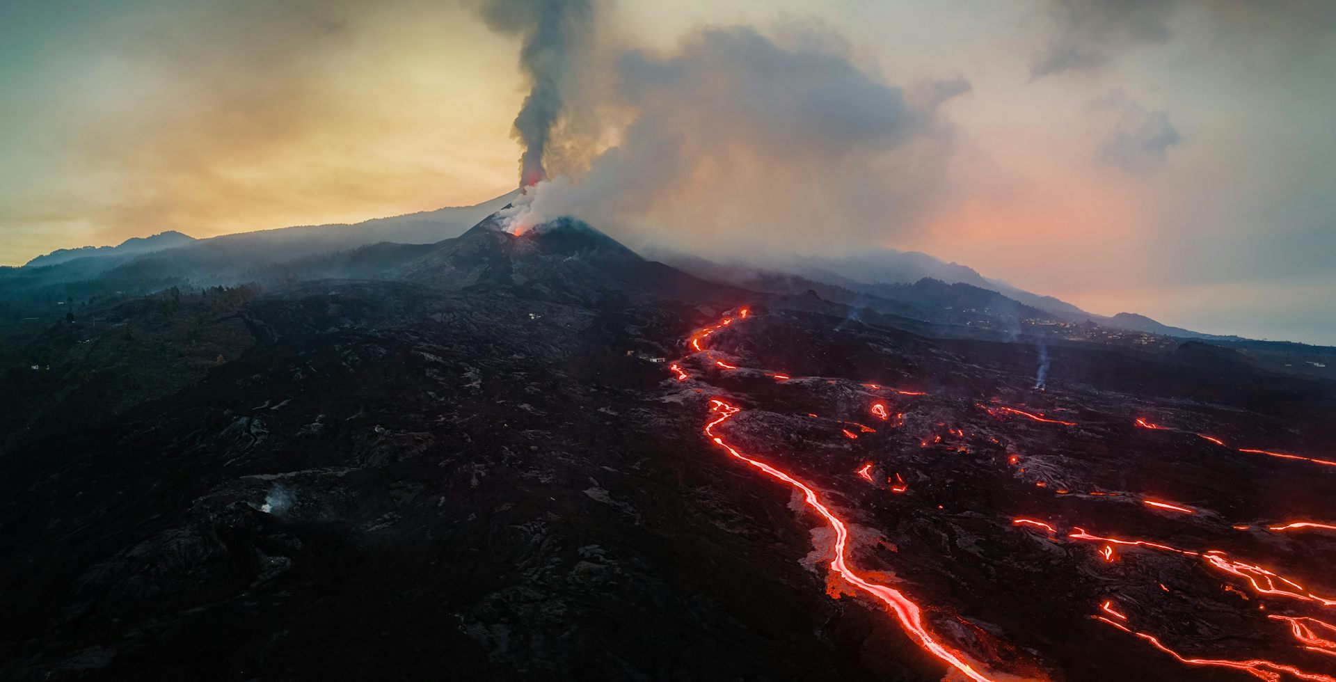 View of the volcano crater, from which incandescent lava flows are escaping.