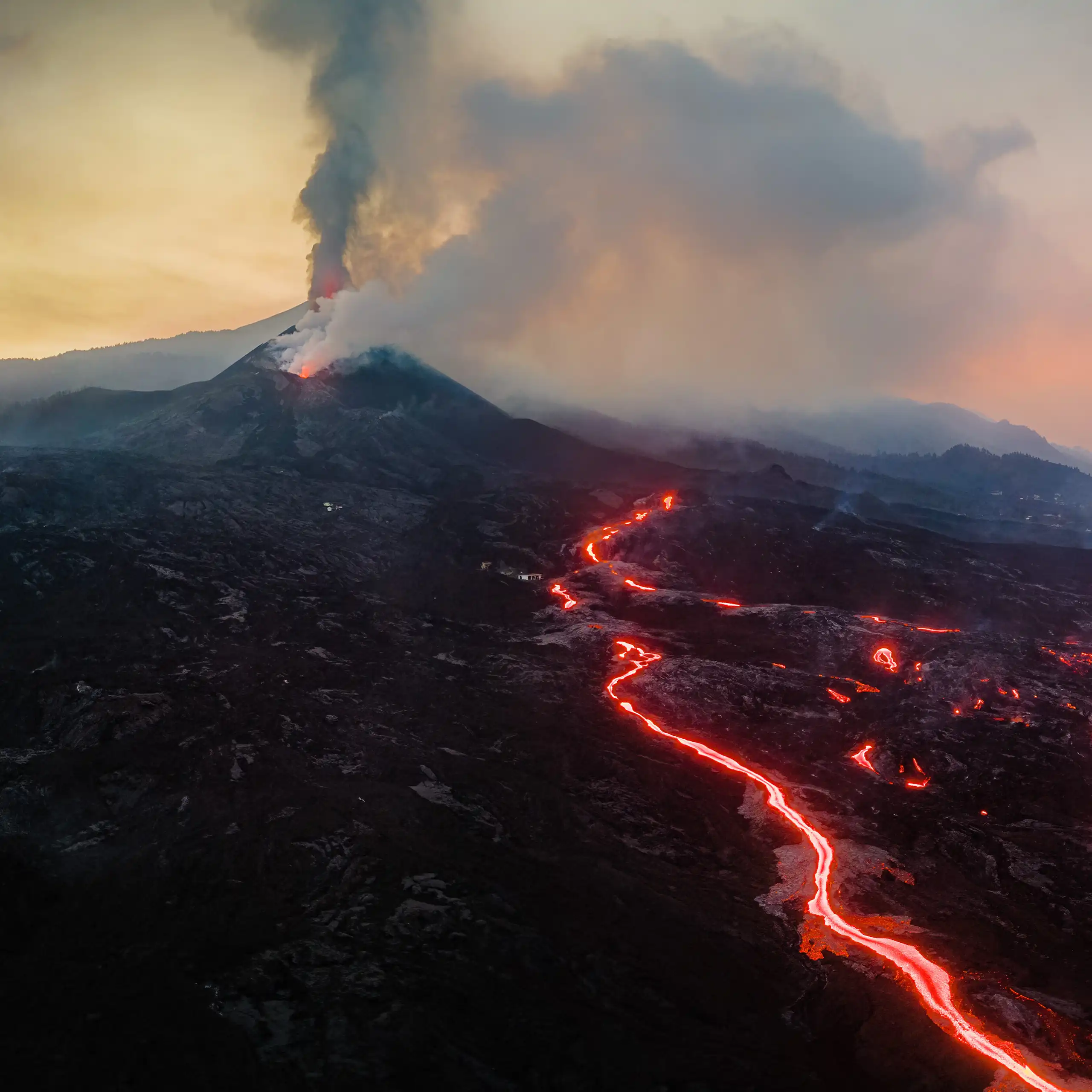 View of the volcano crater, from which incandescent lava flows are escaping.