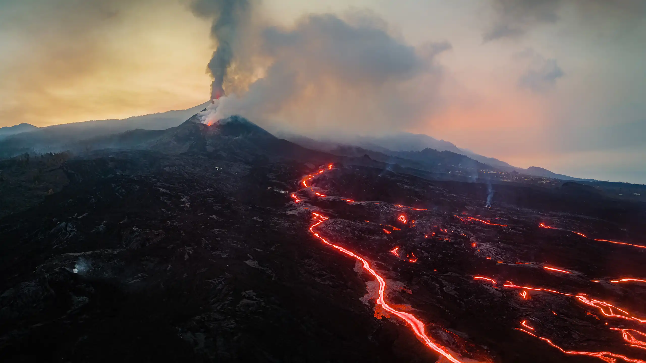 View of the volcano crater, from which incandescent lava flows are escaping.