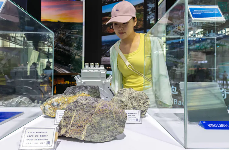 A woman looks at large chunks of rock.