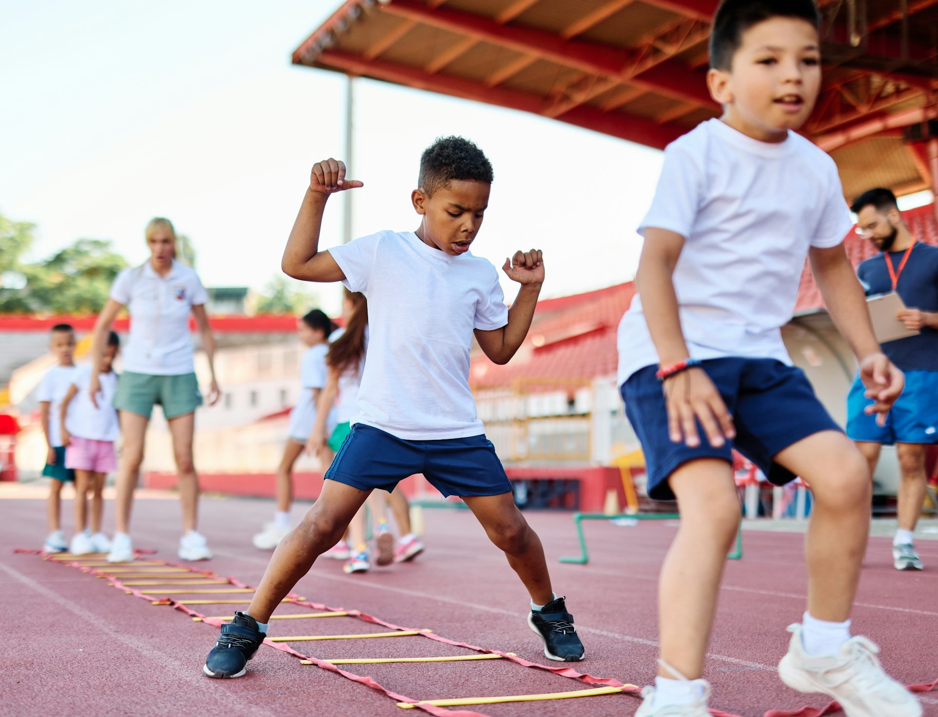 De jeunes enfants font du sport dans un stade.