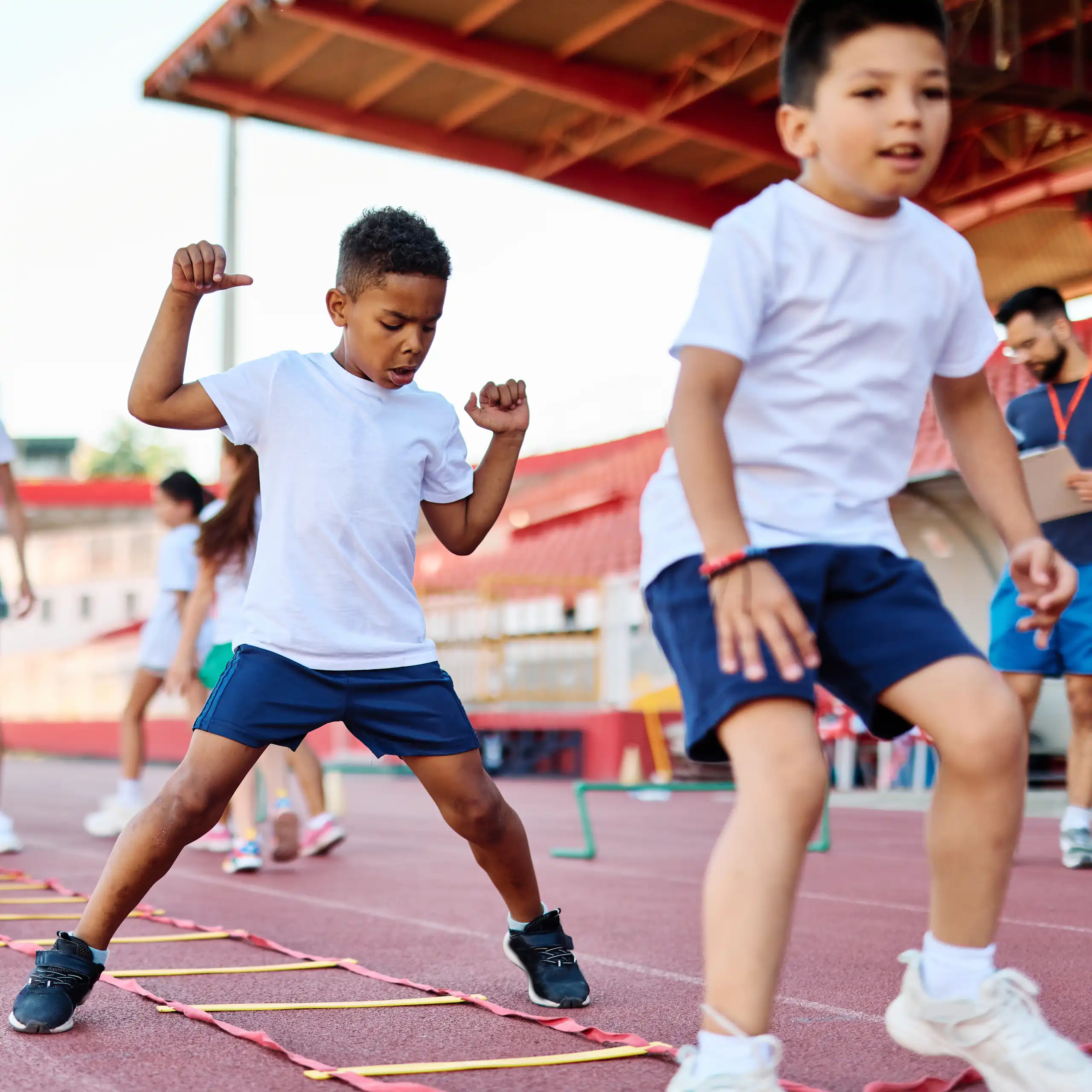 De jeunes enfants font du sport dans un stade.