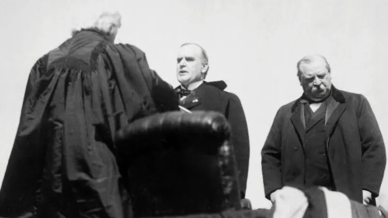 A black-and-white photo of three men dressed in black.