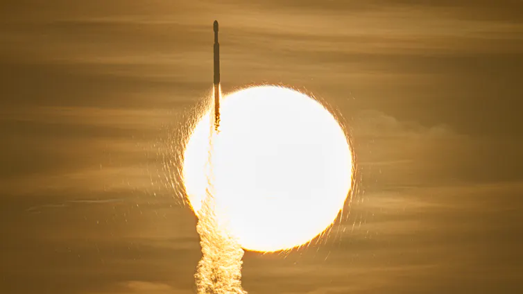 A large glowing orb with a golden sky behind and a rocket travelling upwards in front of it