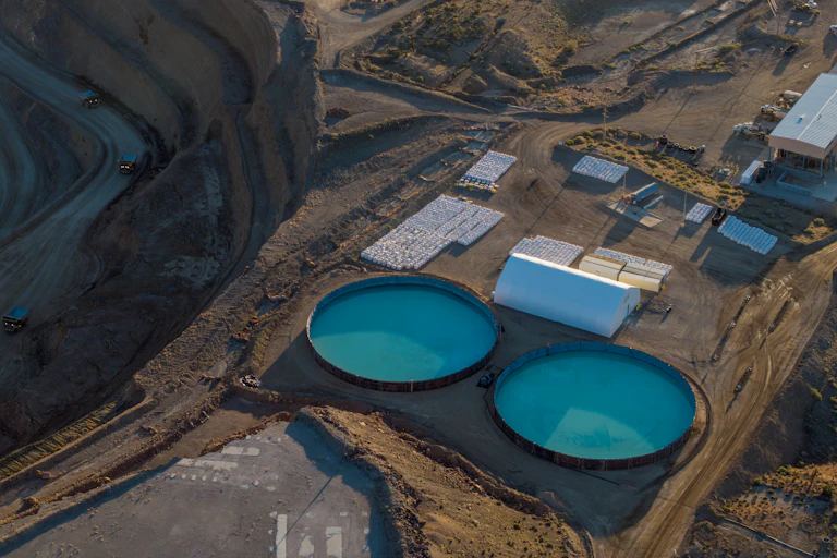 Round pools and mined walls at a rare earths mine in the desert.