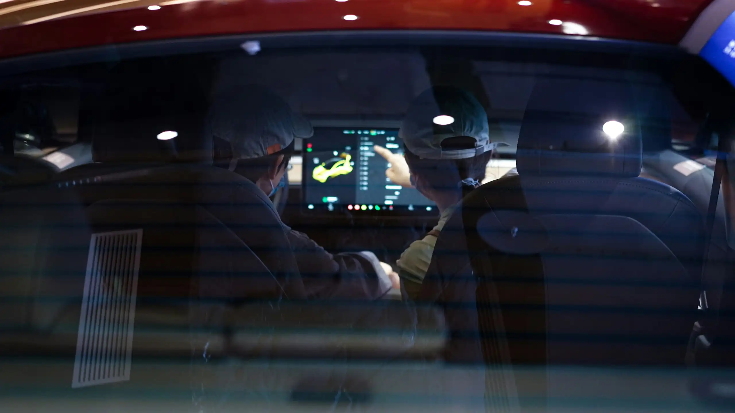 Two people in a car looking at the dashboard screen