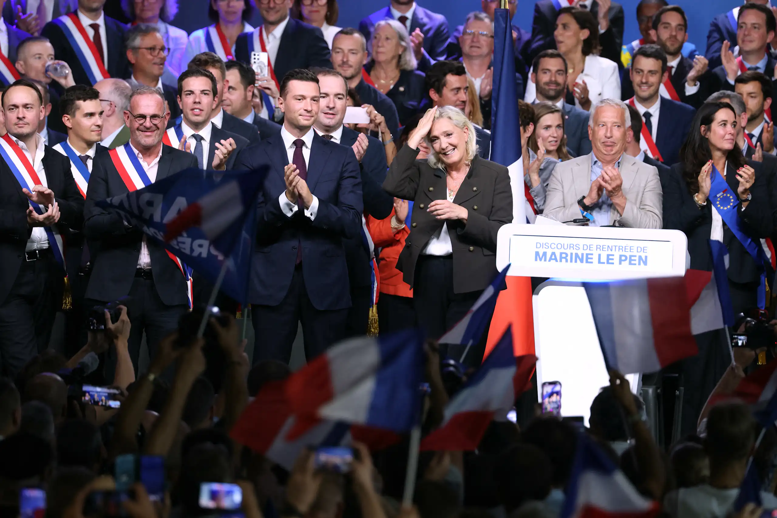 Prise de vue au moment des saluts des personnalités rassemblées sur scène en fin de meeting.