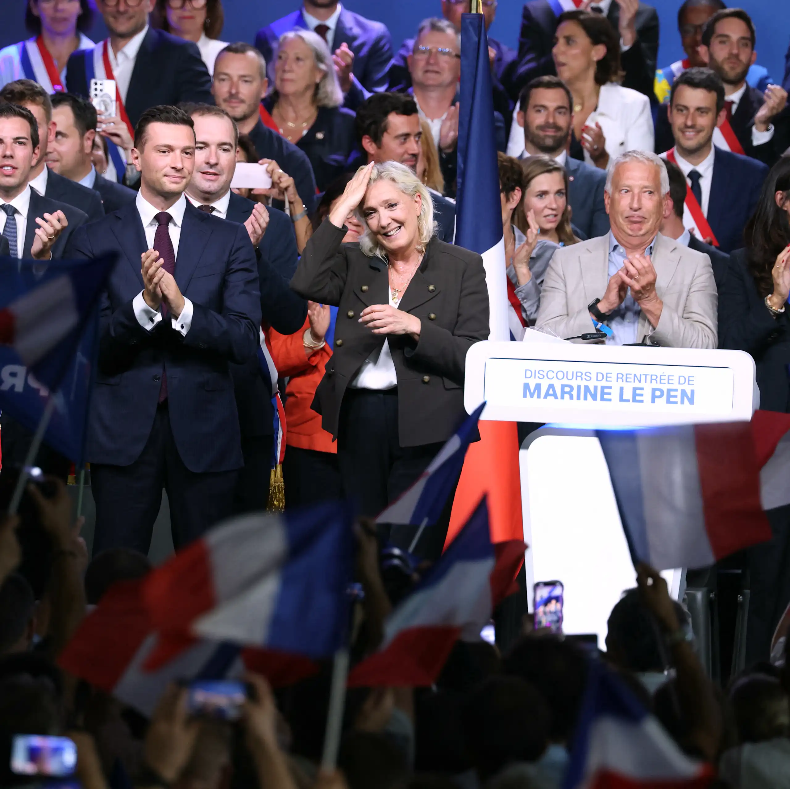 Prise de vue au moment des saluts des personnalités rassemblées sur scène en fin de meeting.